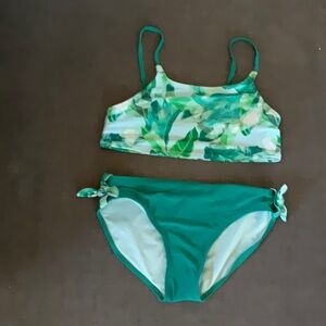 This is a green kids bikini set with palm leaf print on the top